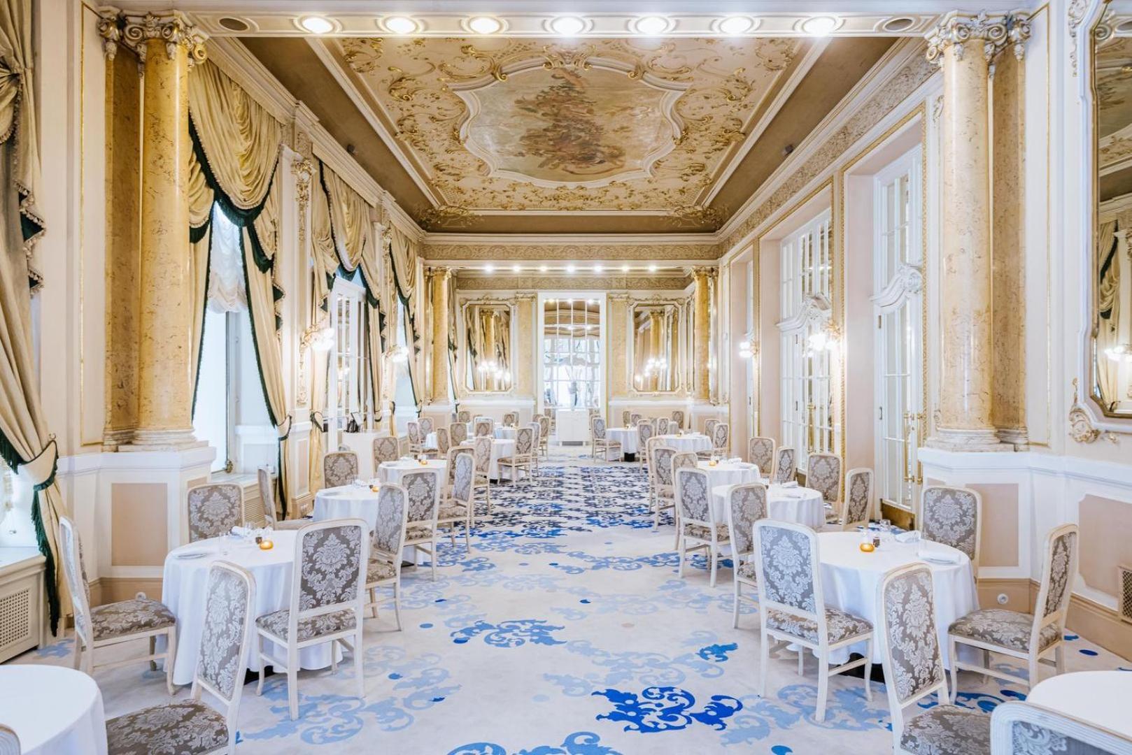 Grandhotel Pupp Karlsbad Buitenkant foto The photo shows an elegantly designed dining room with a luxurious and classic aesthetic. The space features ornate details such as a beautifully painted ceiling, decorative moldings, and large windows that allow natural light to flood in. The decor 